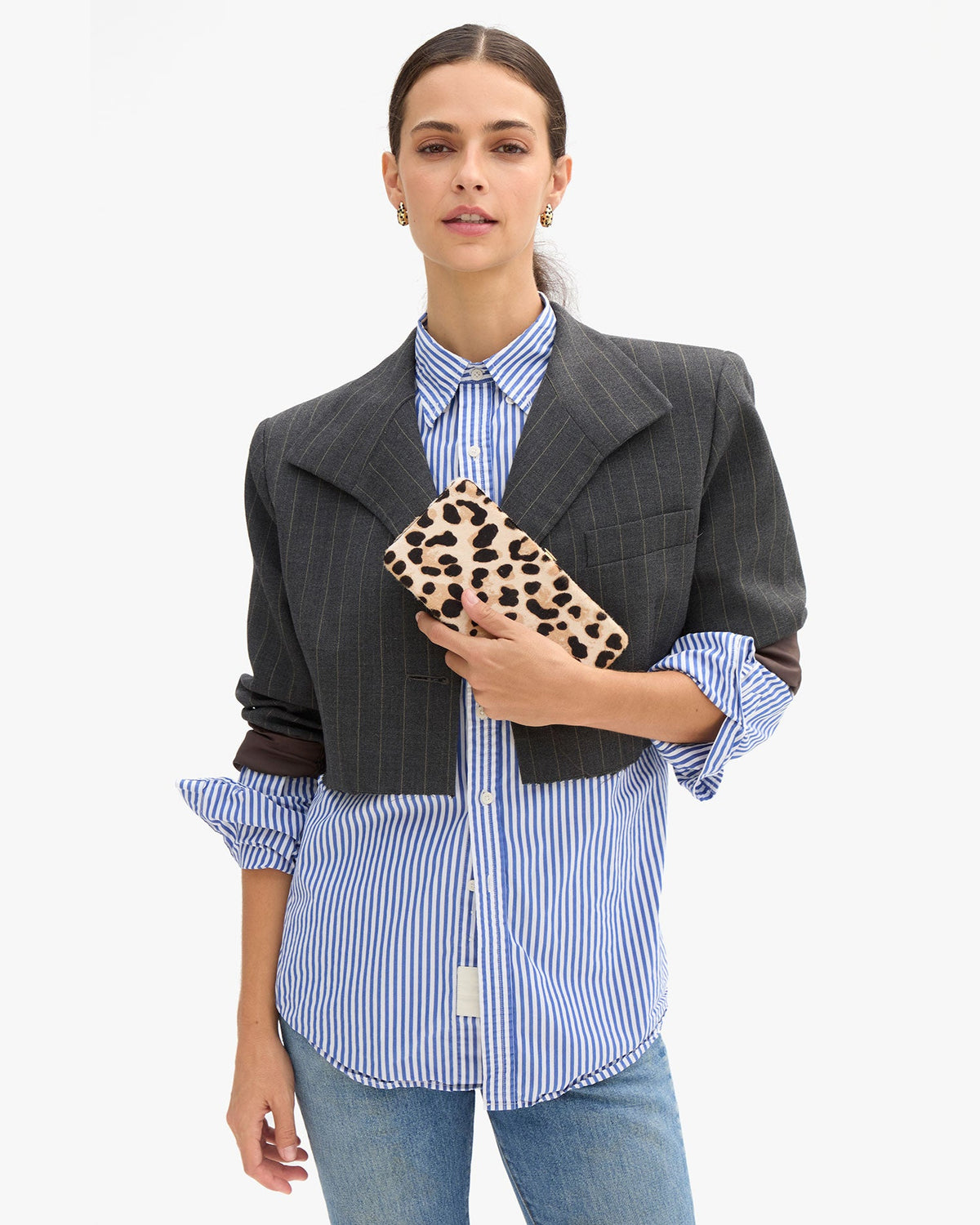Clare V Le Tabac in Cream/Black Snow Leopard Hair-On, shown held by a model