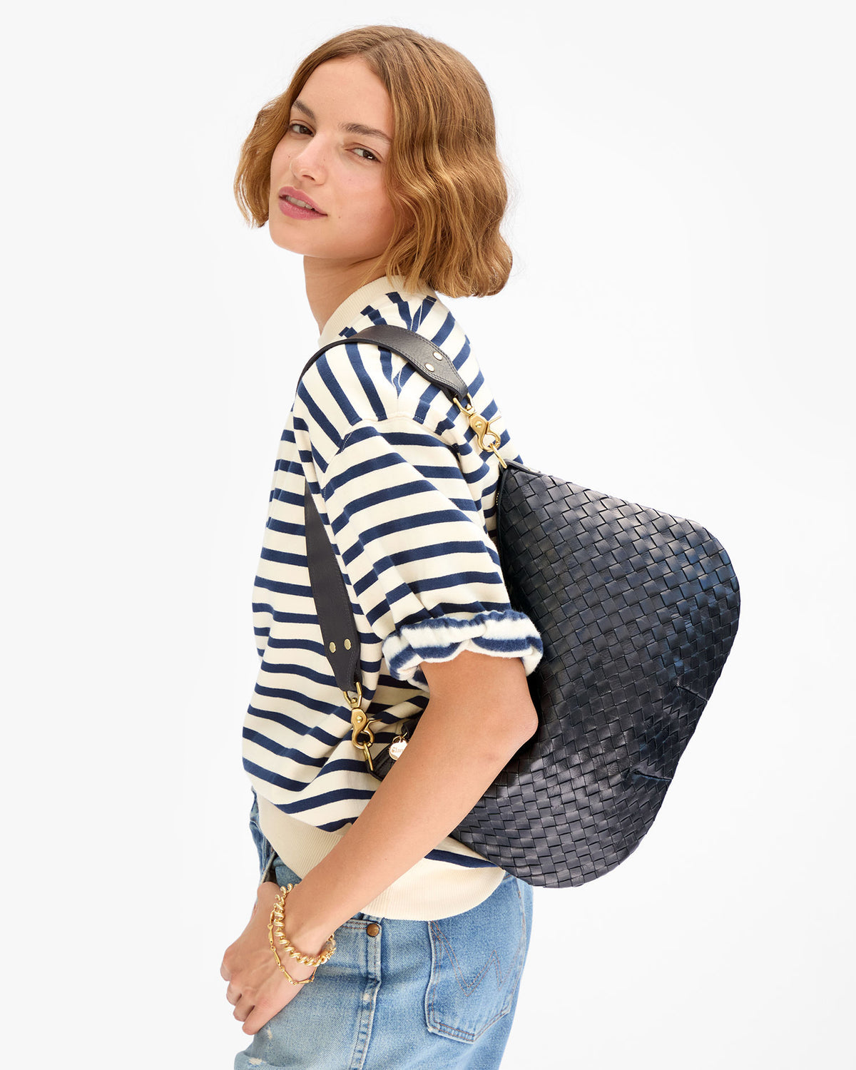 Clare V Moyen Messenger in Twilight Navy Diagonal Woven carried as a shoulder bag by a model