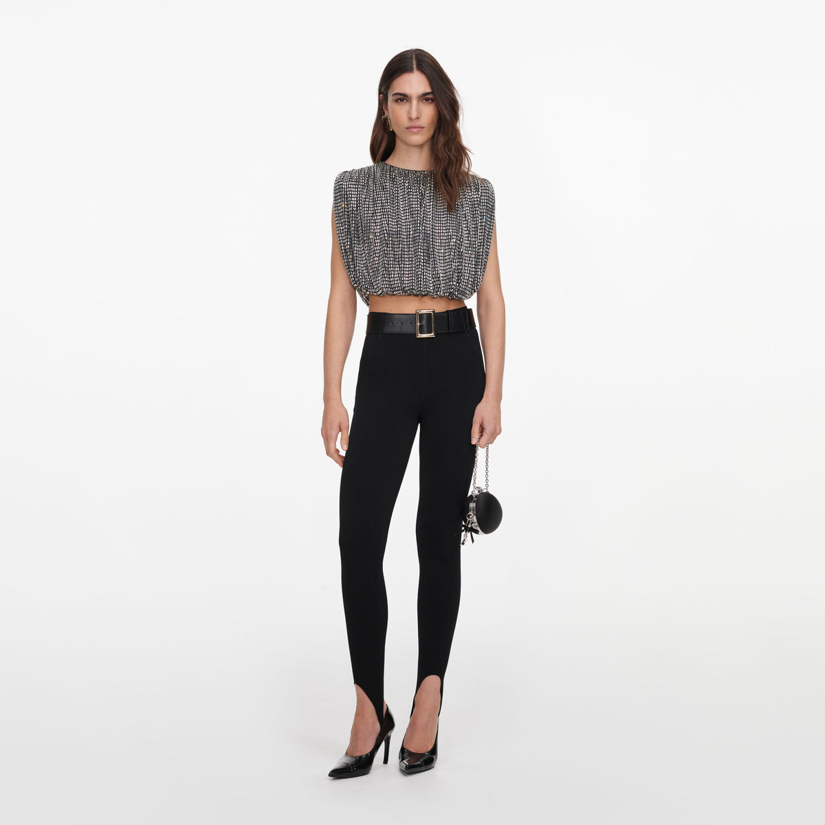 Self Portrait Rhinestone Drape Top in silver, front view, worn cropped with black high waisted pants and heels